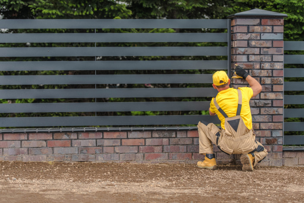 Contractor Installing Metal Paneled Fence